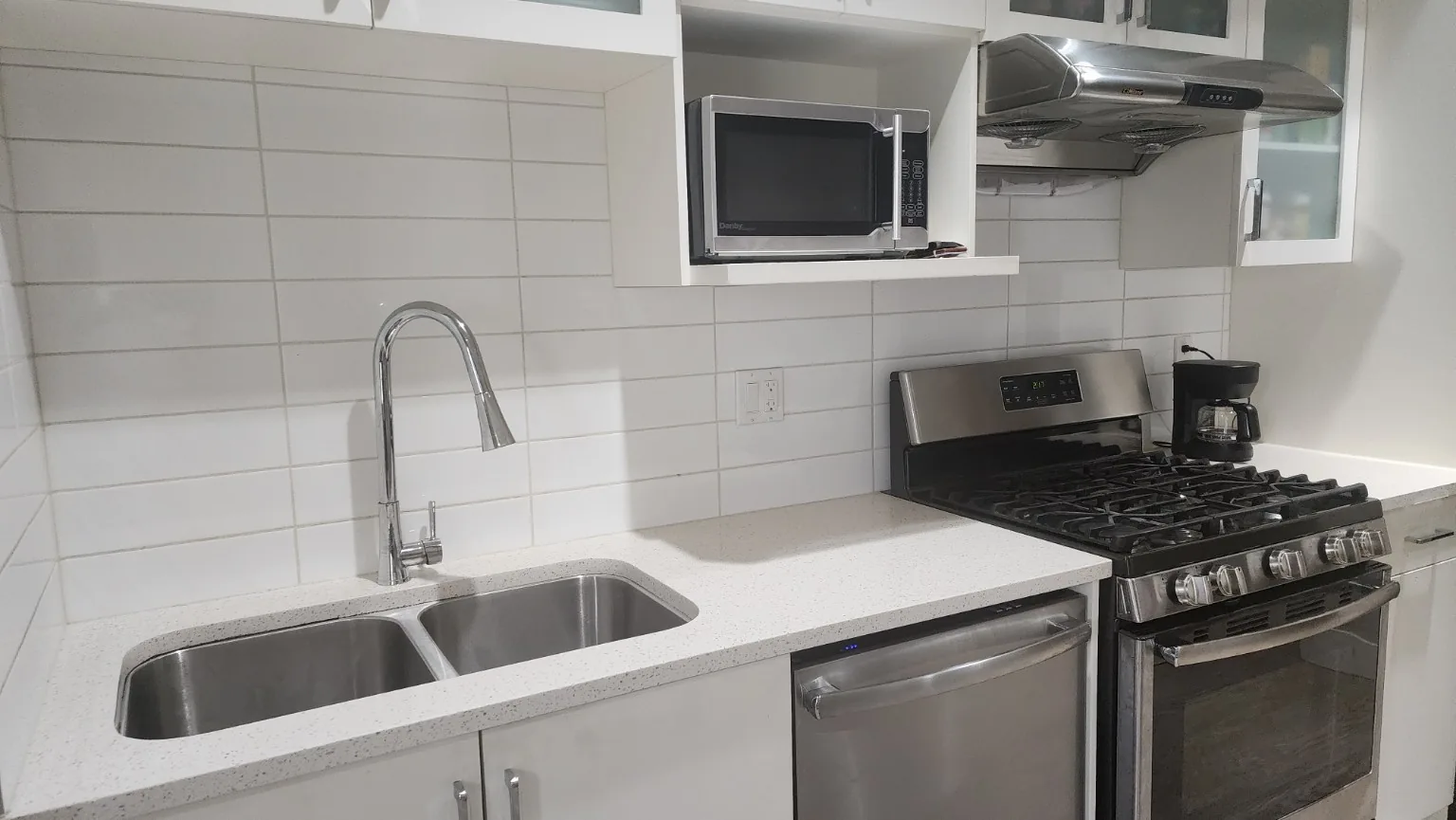 Clean home kitchen with granite counter, appliances, and wood floor